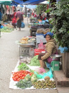 Vendor bundled up to sell her produce.